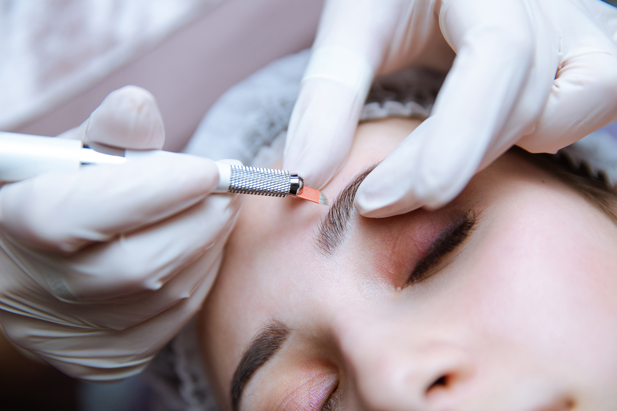 Permanent Makeup For Eyebrows. Microblading brow. Beautician Doing Eyebrow Tattooing For Female Face. Beautiful young girl in a beauty